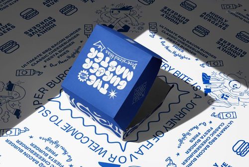 PSD mockup showing a blue burger box with bold white design elements, surrounded by themed food-related drawings.