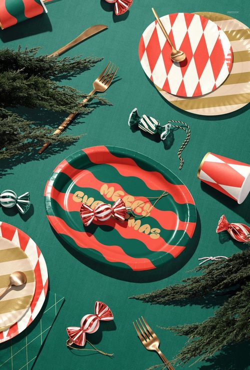 Festive mockup scene showing red and green striped plates, wrapped candies, and gold utensils for holiday decor.