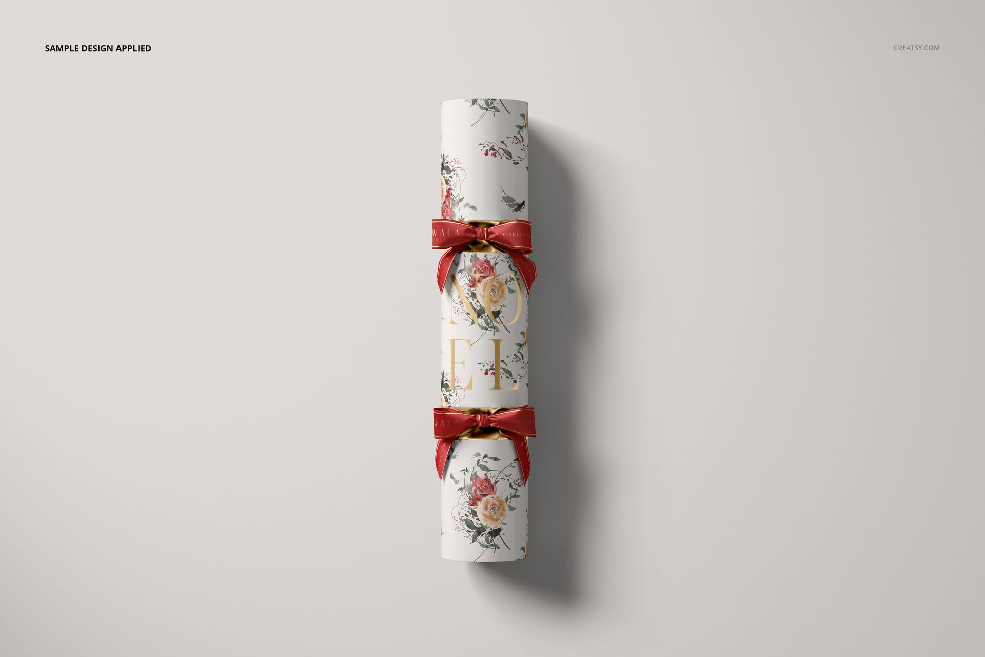 Christmas cracker mockup featuring a cylindrical shape with floral patterns and red ribbons, shown from a top view on a light background.