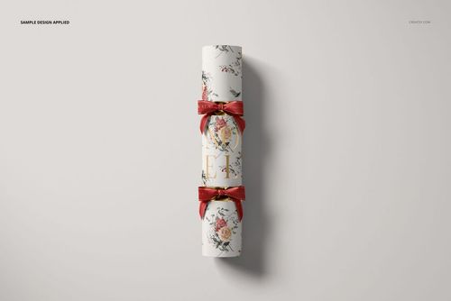 Christmas cracker mockup featuring a cylindrical shape with floral patterns and red ribbons, shown from a top view on a light background.
