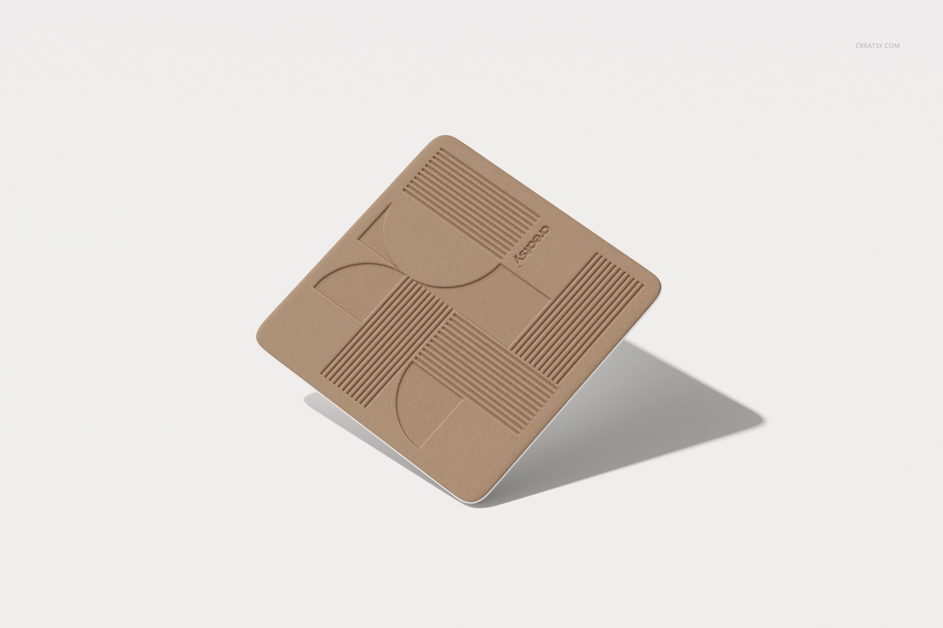 Single square drinkware coaster mockup featuring abstract embossed lines and shapes, shown in a floating perspective.