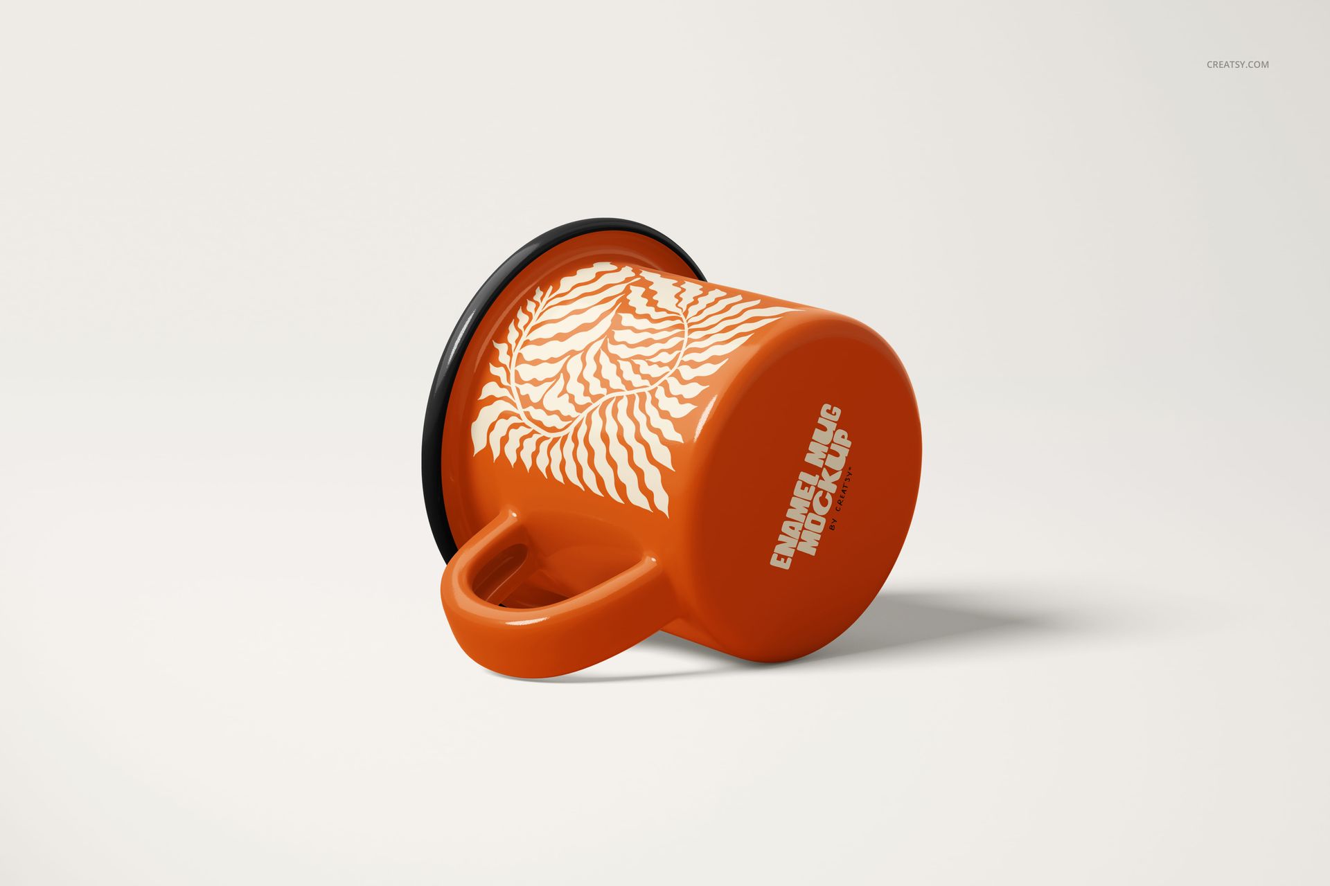 Orange enamel mug with white abstract pattern, shown lying on its side on a light background, front view.