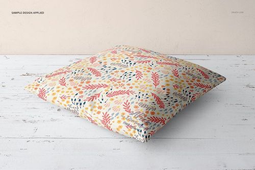 Fabric Factory PSD mockup showing a square pillow with multicolored botanical design on a white rustic floor.