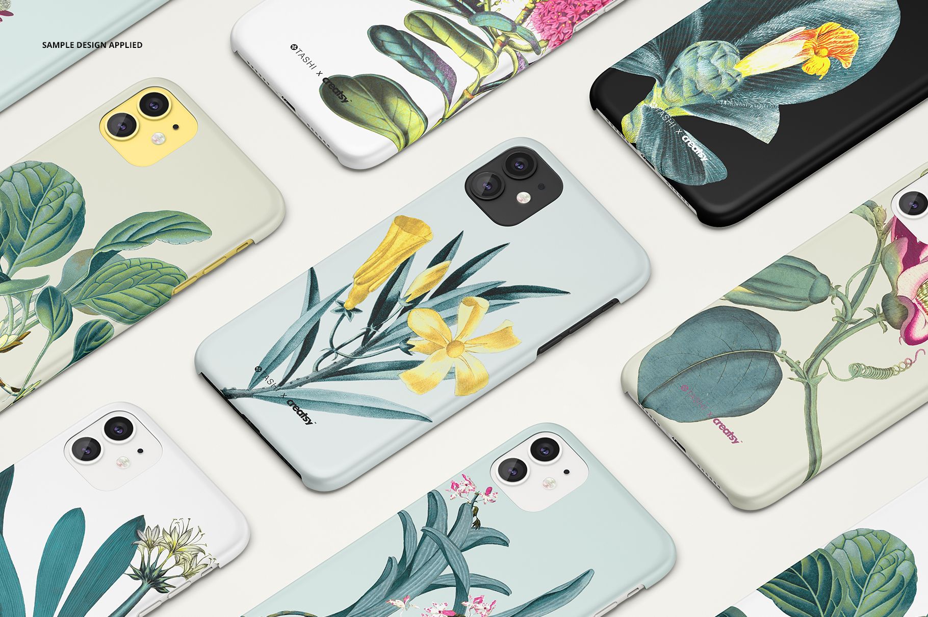 Botanical-themed iPhone 11 matte snap case mockup set with various plant prints spread out on a pale surface.