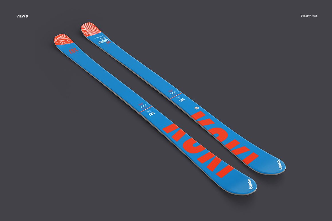 Sport equipment PSD mockup of blue skis with orange patterns, presented in a perspective view against a gray backdrop.