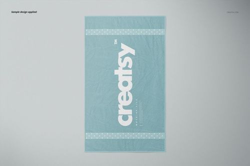 Bath towel mockup featuring a soft blue color, white branding, and polka dot accents, shown in a flat lay perspective.