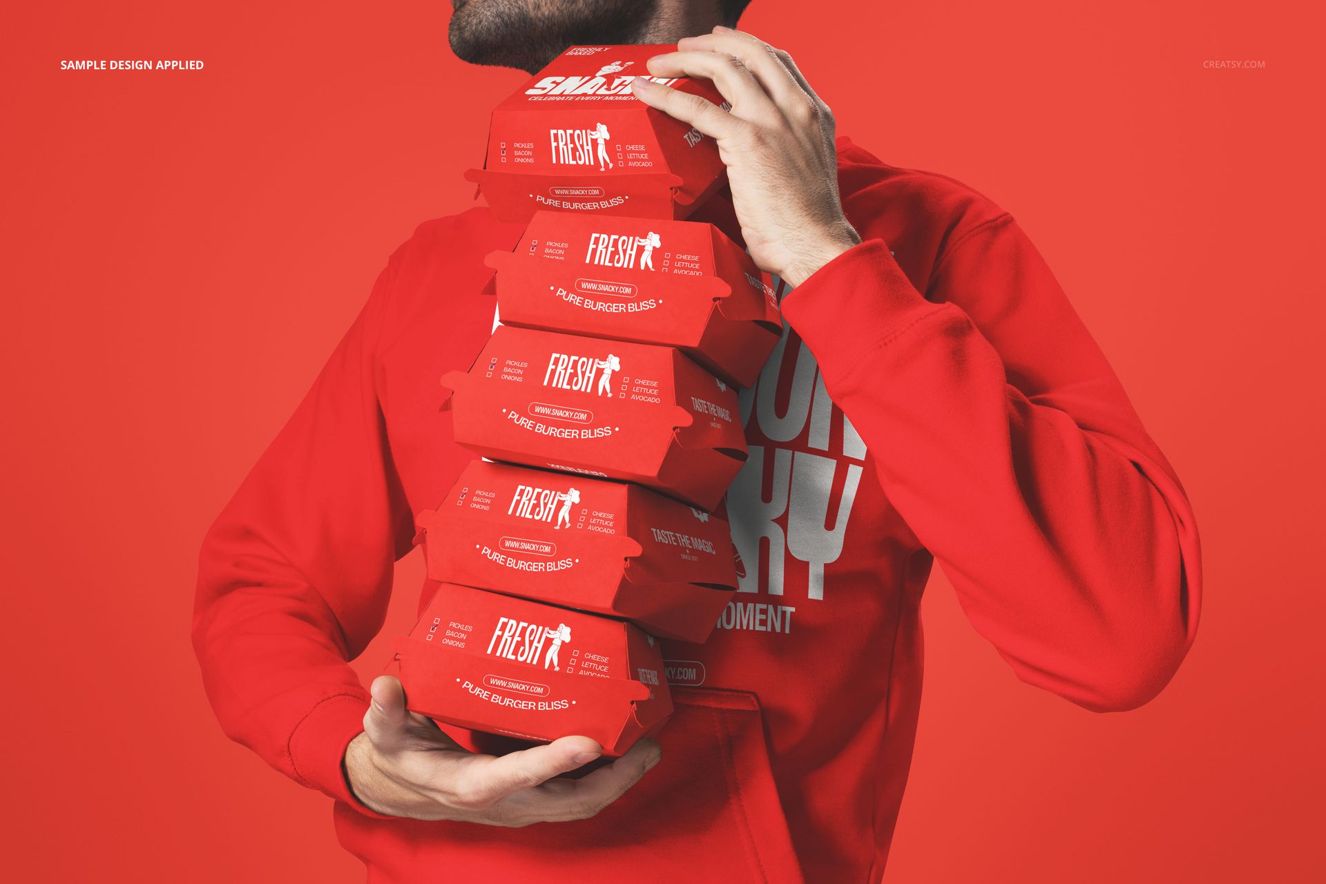 PSD mockup showing a person gripping multiple red burger packaging boxes, with a vibrant monochrome red scene.