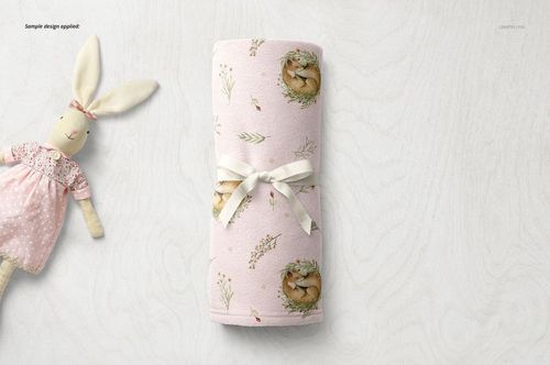 Rolled baby blanket mockup in soft fleece, light pink color, decorated with delicate animal and floral motifs.