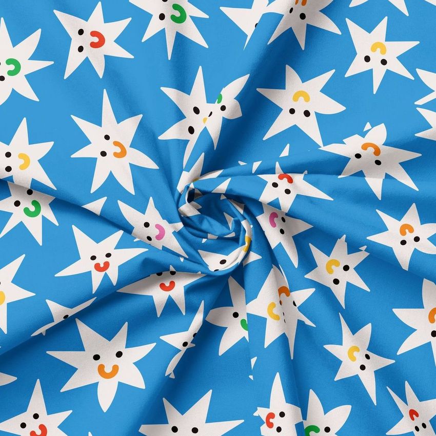 Creased fabric mockup featuring a blue textile with a repeating pattern of white star shapes, each with a smiling face.