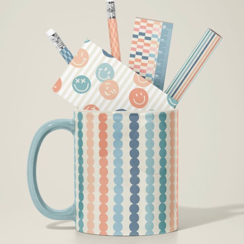 Mug mockup with pastel striped pattern, filled with office supplies like pencils, ruler, and notepad decorated with playful designs.