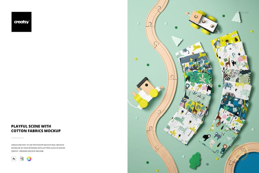 PSD mockup showing assorted cotton fabrics with whimsical designs, surrounded by toy trains and miniature trees.