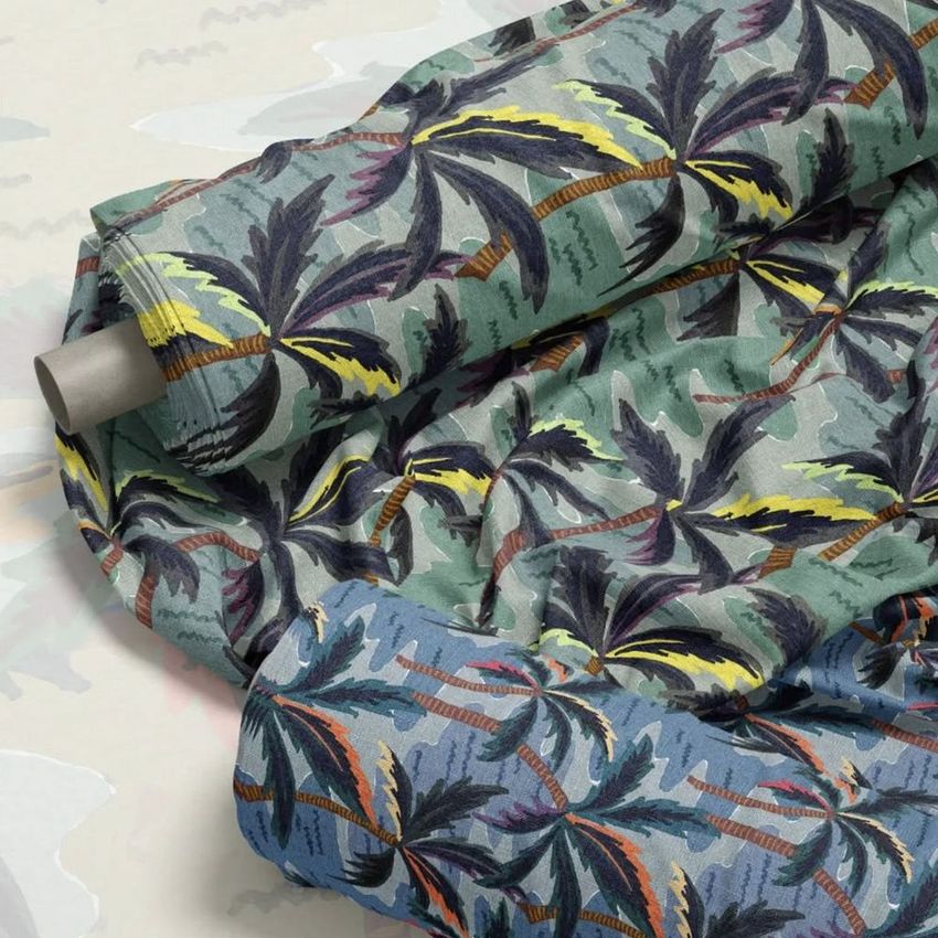 Fabric rolls mockup featuring tropical palm tree patterns in green and blue tones, displayed on a light patterned surface.