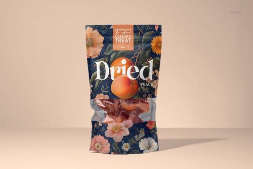 Standing paper bag mockup featuring dried peach pieces inside, decorated with colorful flowers and soft background.