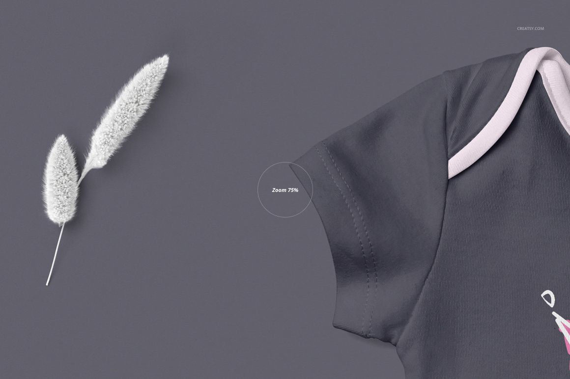 PSD mockup featuring a partial view of a baby onesie in dark gray with pale trim, placed beside soft white plants.