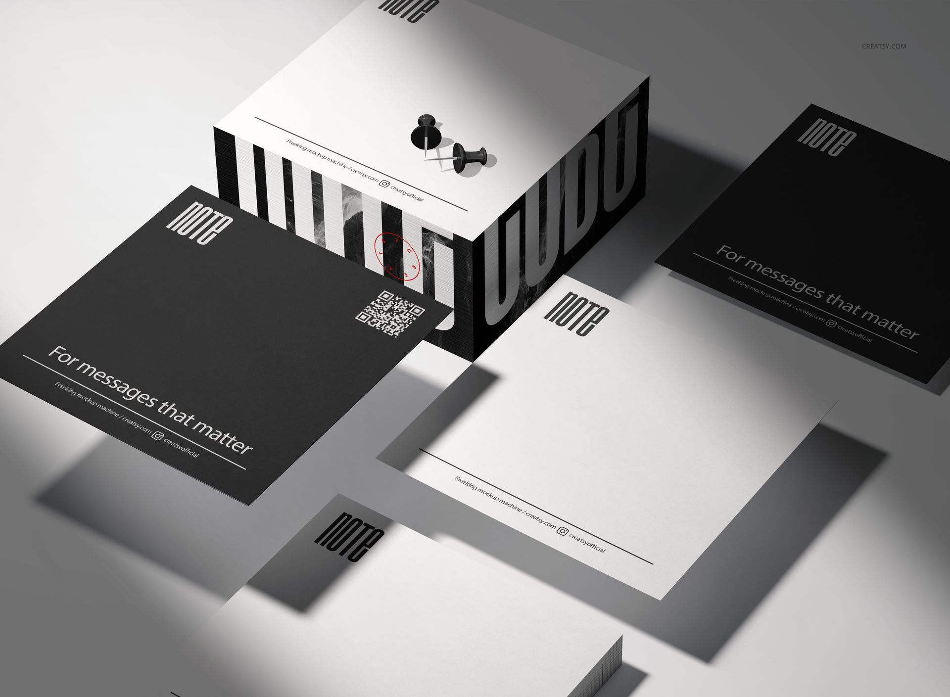 Stationery note cube mockup set with black and white square sheets, box packaging, and push pins in a studio setting.