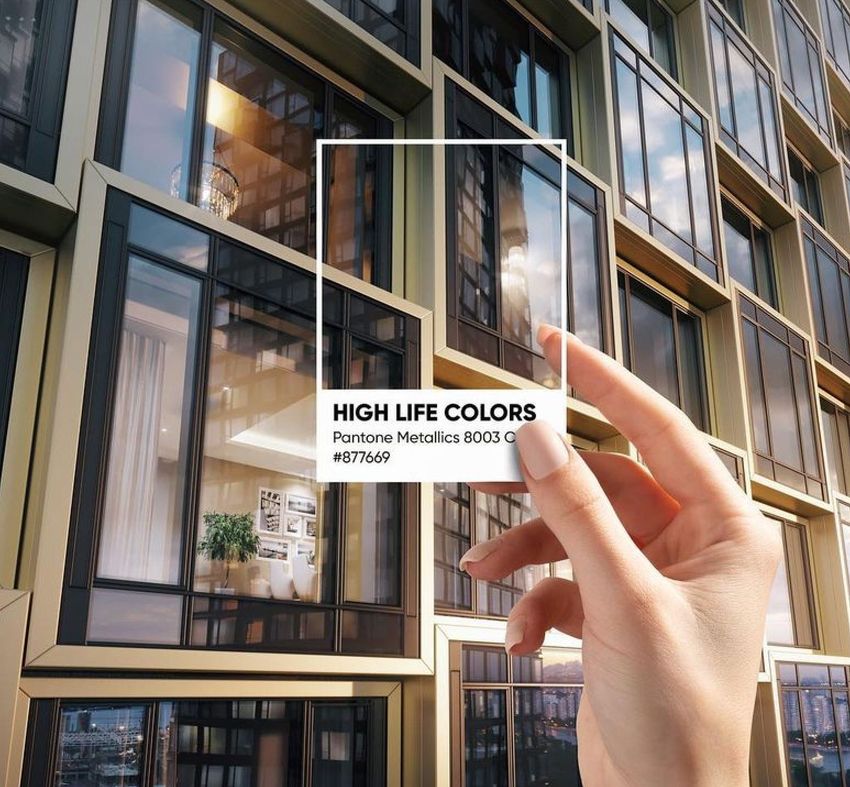 Hand holding a transparent card with text in front of a modern building facade with large glass windows and gold frames.