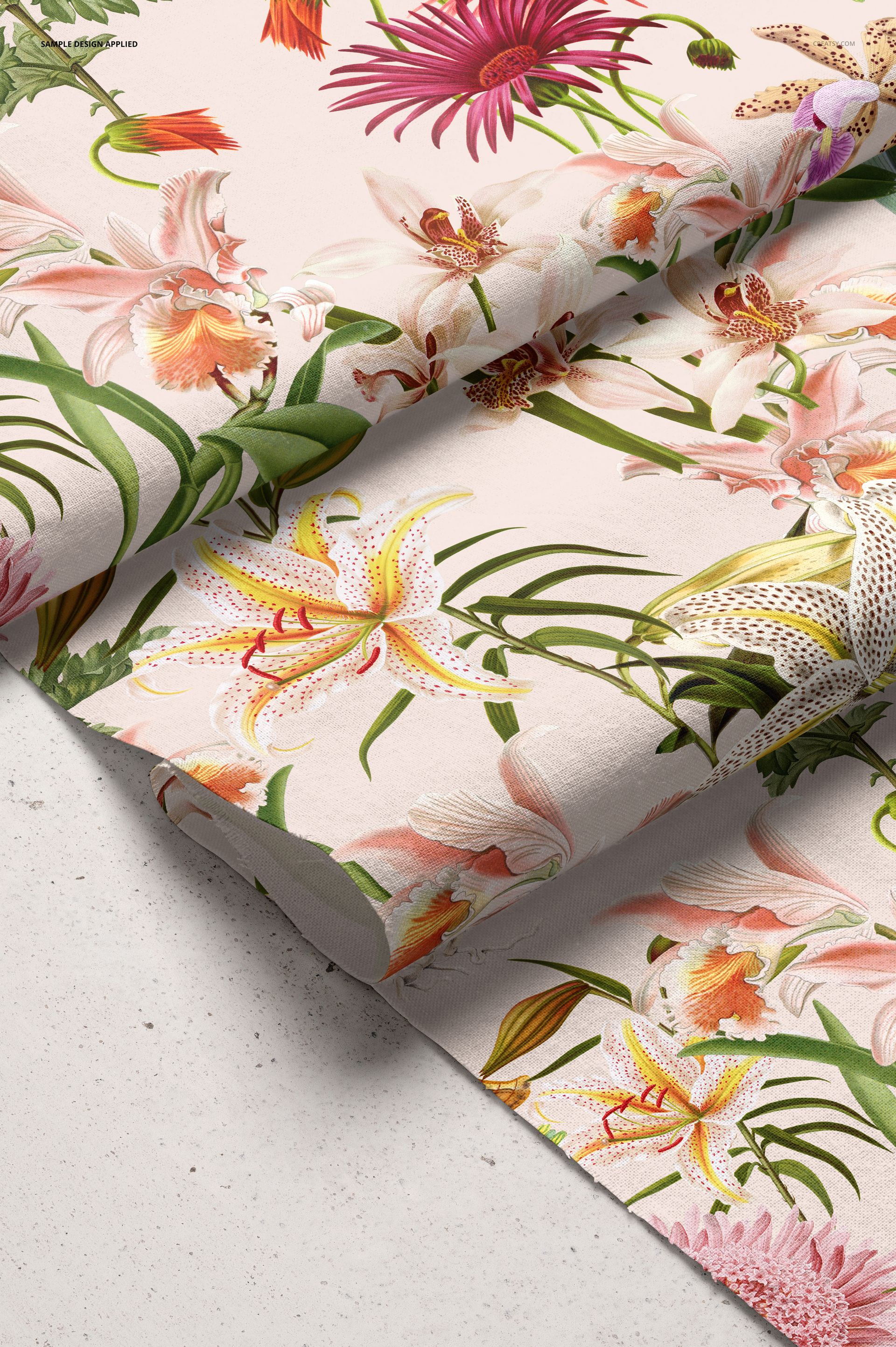 Cotton fabric mockup displaying a vibrant mix of pink, yellow, and orange flowers on a light background, angled view.