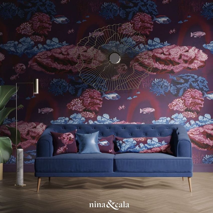 Retro living room mockup featuring a blue tufted sofa with decorative pillows, set against a coral reef patterned wallpaper.