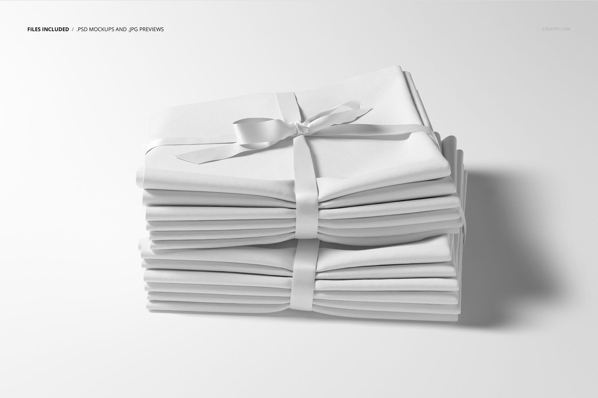 White textile mockup featuring multiple folded fabrics stacked and tied with a ribbon, front perspective.