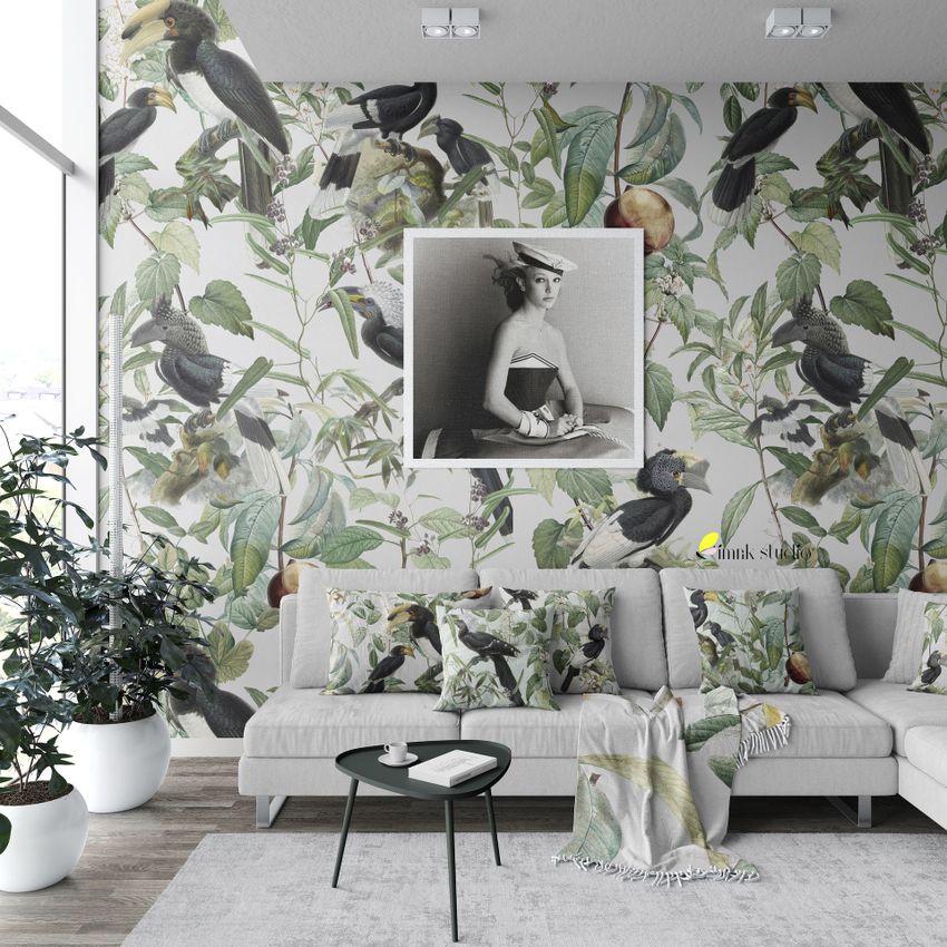Modern living room sofa mockup with a light gray sectional sofa, patterned pillows, and a botanical bird wallpaper in the background.