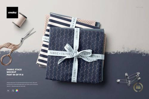Top view of a fabric stack mockup featuring assorted folded textiles with ribbon, scissors, and sewing props.