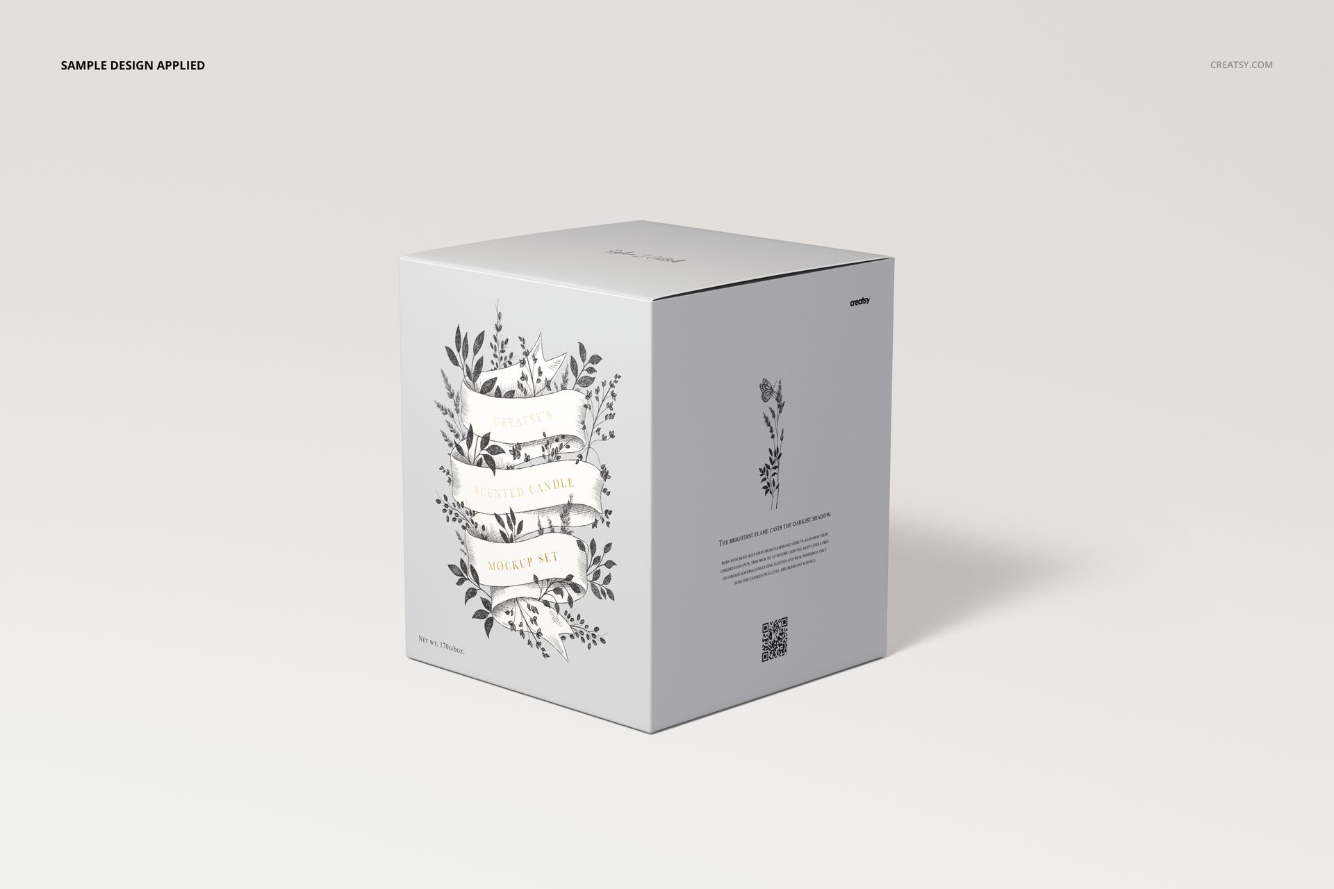 Square candle packaging mockup with floral graphics and decorative text, displayed on a light neutral background.