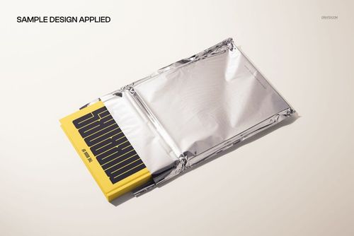 PSD mockup showing a hardback book with a graphic cover peeking out of a reflective metallic foil mailer.
