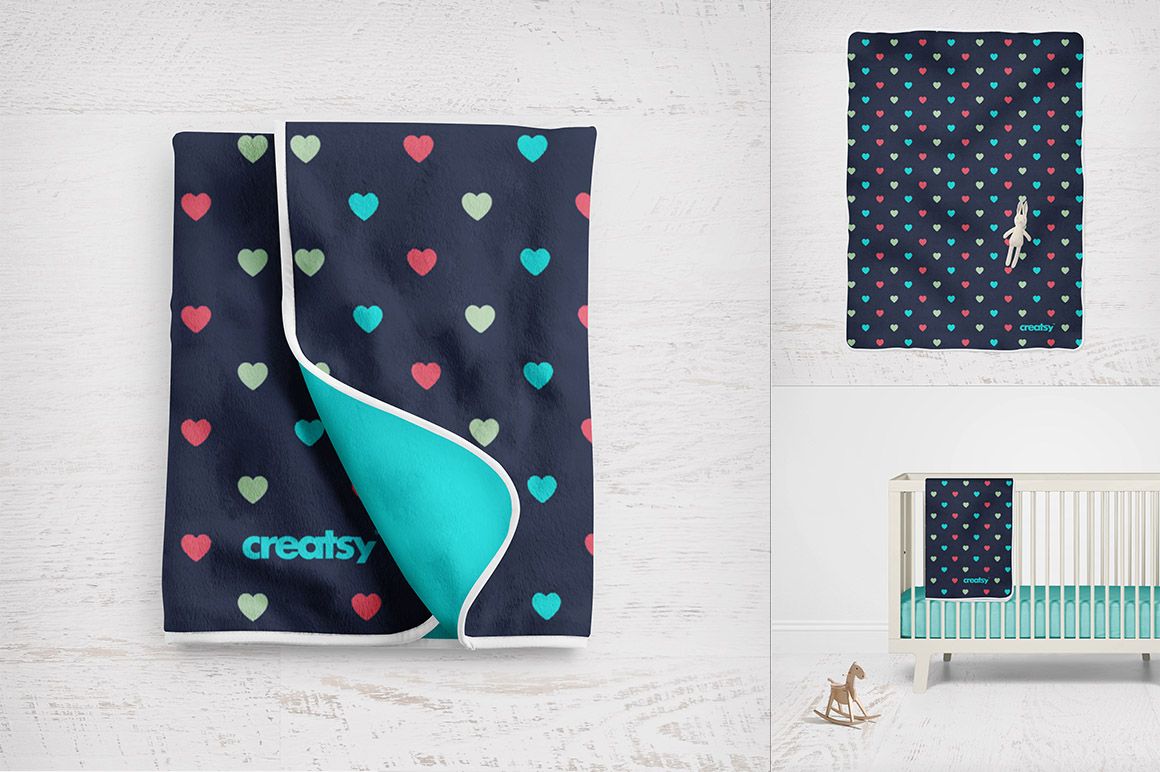 PSD mockup of a baby fleece blanket featuring multicolored hearts, displayed folded and on a white wood background.
