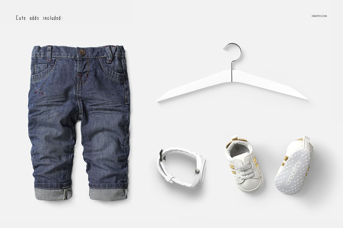 Rolled-up blue baby jeans, white hanger, white bracelet, and two white baby shoes with gold stripes on a light background.