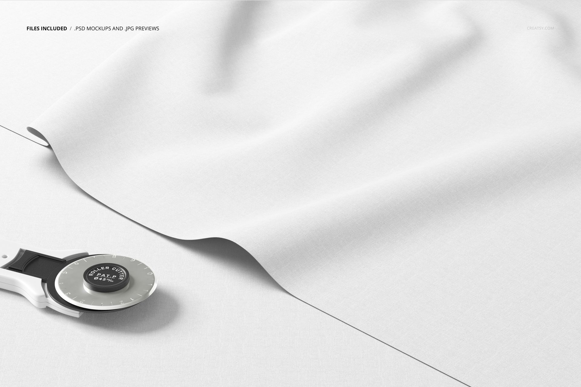 Close-up of layered textile mockup with smooth white fabric and a rotary cutter on a clean, light background.