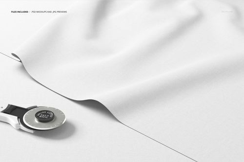 Close-up of layered textile mockup with smooth white fabric and a rotary cutter on a clean, light background.