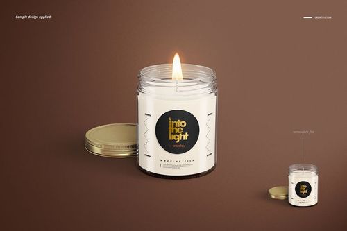 Jar candle mockup featuring a burning candle in a clear glass jar, gold lid off to the side, brown backdrop.