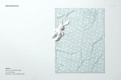 Top view of a 30x40 fleece blanket mockup with a pastel polka dot pattern and a soft bunny toy as a prop.