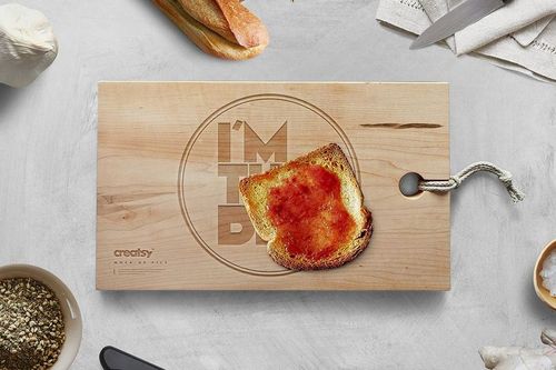 Rectangular engraved wooden board mockup with toast and jam on top, viewed from above on a kitchen counter.