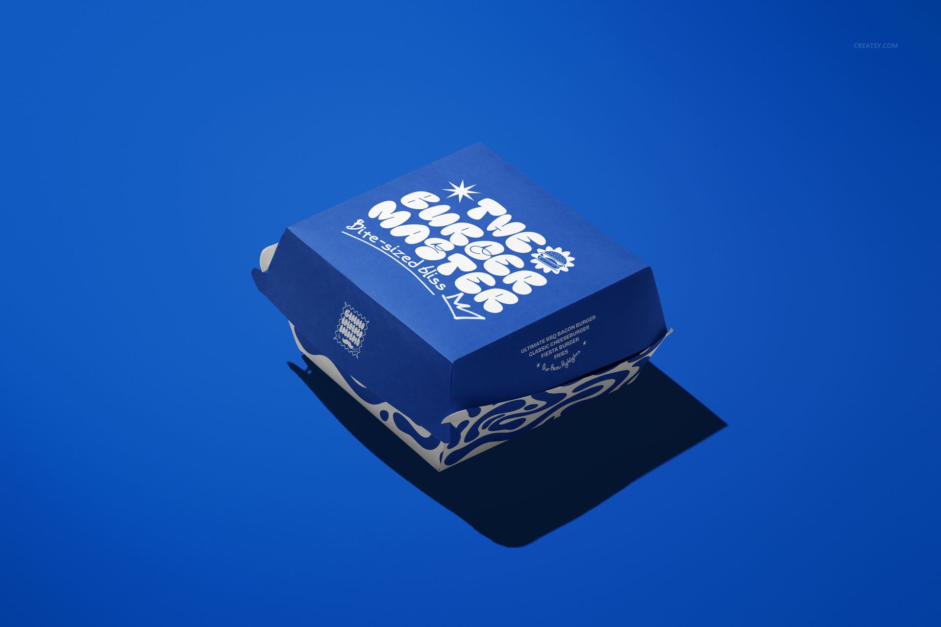 Blue burger packaging mockup with white decorative patterns and vegan branding, shown from an angled perspective.