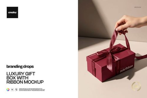 Rectangular luxury gift box in deep red with a satin ribbon bow, shown in a mockup scene with soft shadows.
