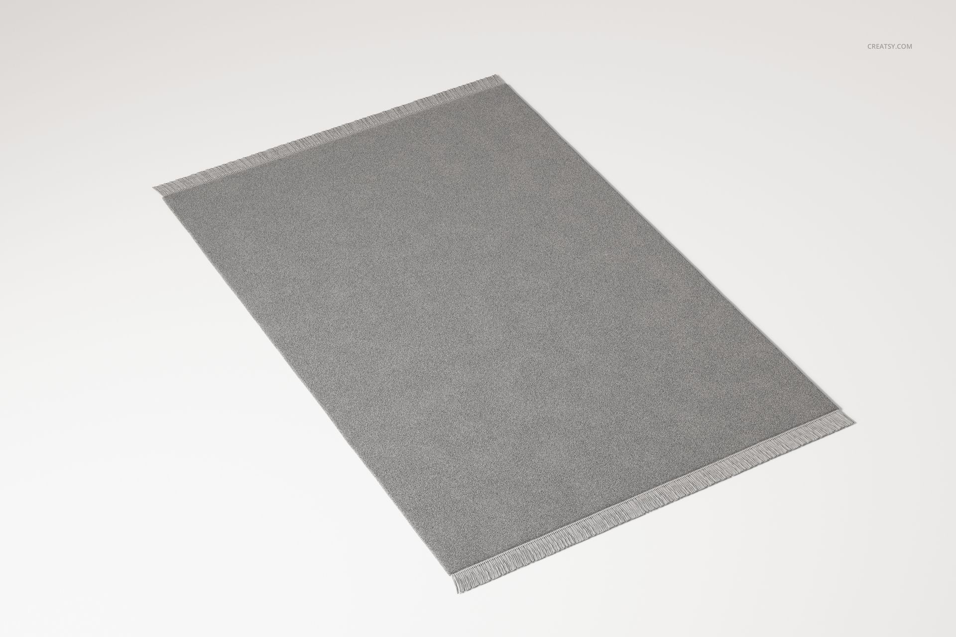 Large rectangular fringed rug in solid gray color, viewed from a slightly angled top perspective on a white surface.