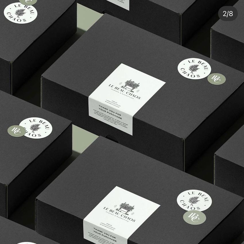 Mailing boxes mockup featuring several black boxes with white stickers and labels arranged in a grid pattern on a flat surface.