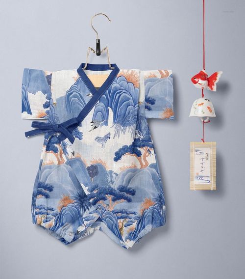 Front view of a baby romper mockup featuring traditional Japanese landscape designs in blue, displayed beside a Furin wind chime.