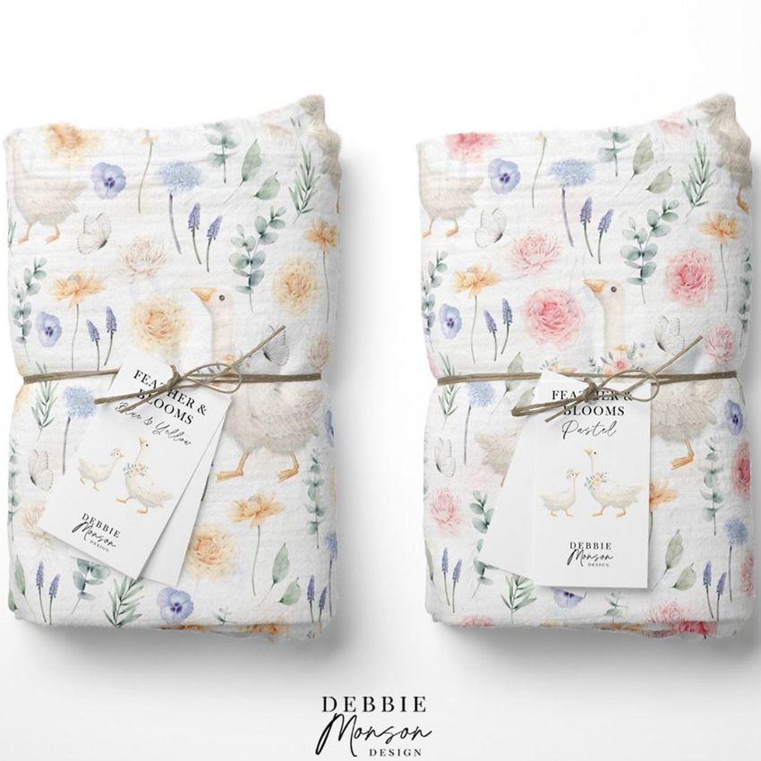 Muslin swaddle blanket mockup showing two folded blankets with pastel floral and goose patterns, each tied with string and a product tag, on a white background.
