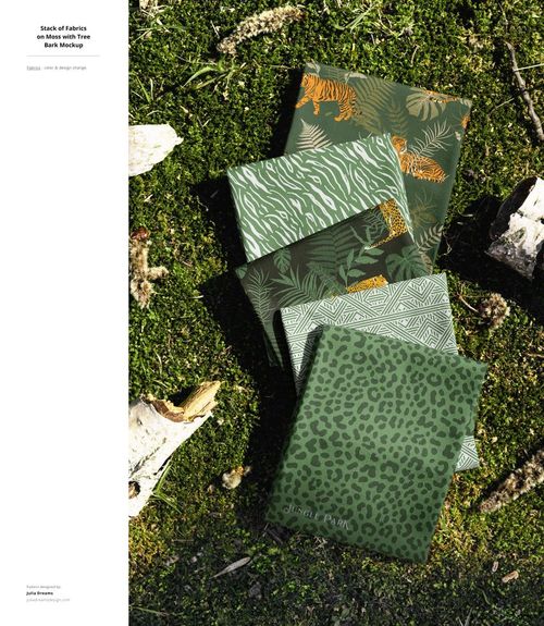 Outdoor scene showing patterned fabric mockups in green tones, displayed on moss with natural elements around.