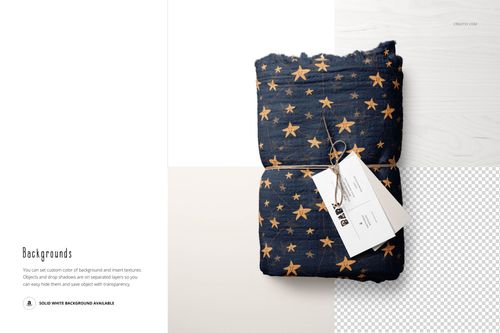 PSD mockup of a muslin swaddle blanket with a golden star motif, shown folded and tied with a label on a pale textured surface.