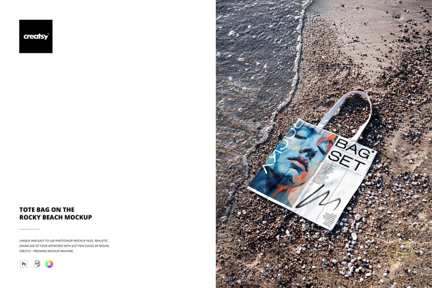 Tote bag with abstract blue and orange design lying on rocky beach near water, shown in a top view mockup scene.