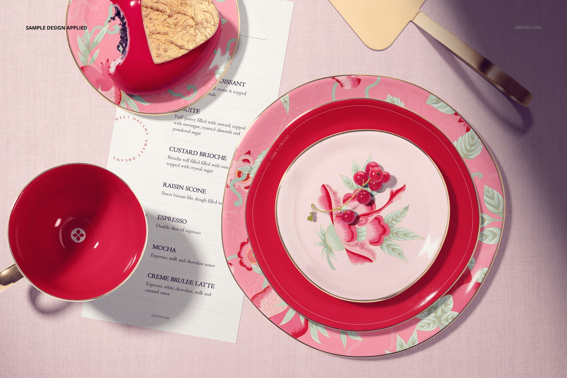 Top view of a Valentine's cake plate mockup set with pink and red floral patterns, cup, and utensils on a table.