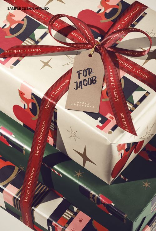 PSD mockup of holiday gift boxes featuring decorative wrapping, a ribbon with 'Merry Christmas' text, and a personalized tag.