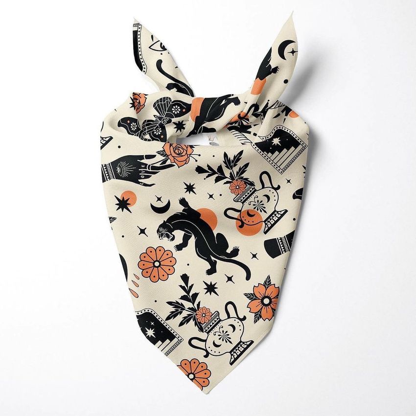 Pet bandana mockup featuring a beige fabric with black and orange mystical panther and floral illustrations on a white background.