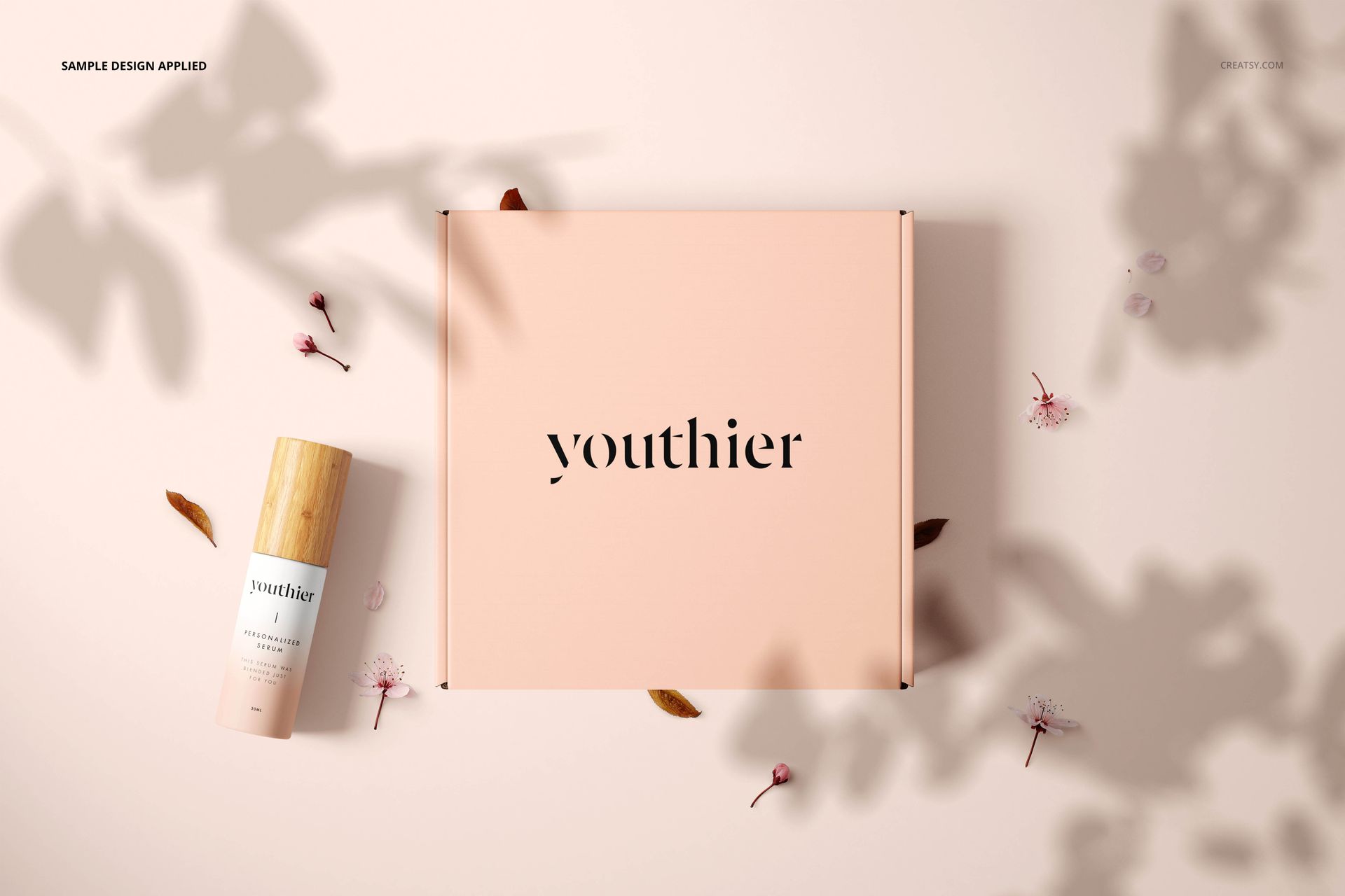 Cosmetic packaging mockup featuring a pastel pink box and a wooden-capped bottle, surrounded by leaves and flower petals.