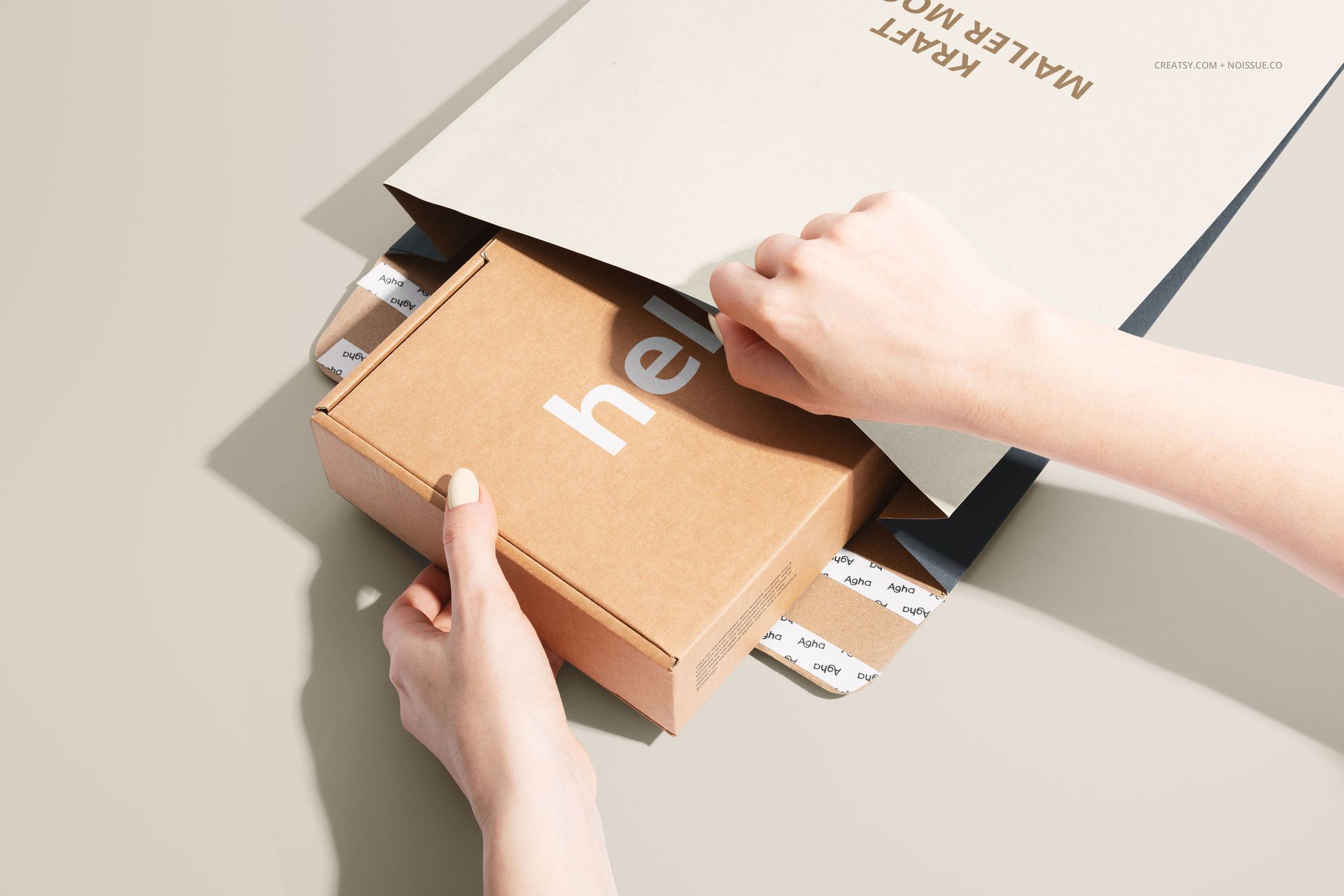 Kraft mailer box with visible white lettering being slid into a kraft envelope, shown from an angled top view in a PSD mockup.