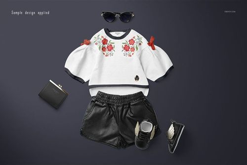 Kids sweater mockup featuring a white top with floral design, black shorts, shoes, and wallet on a dark background.