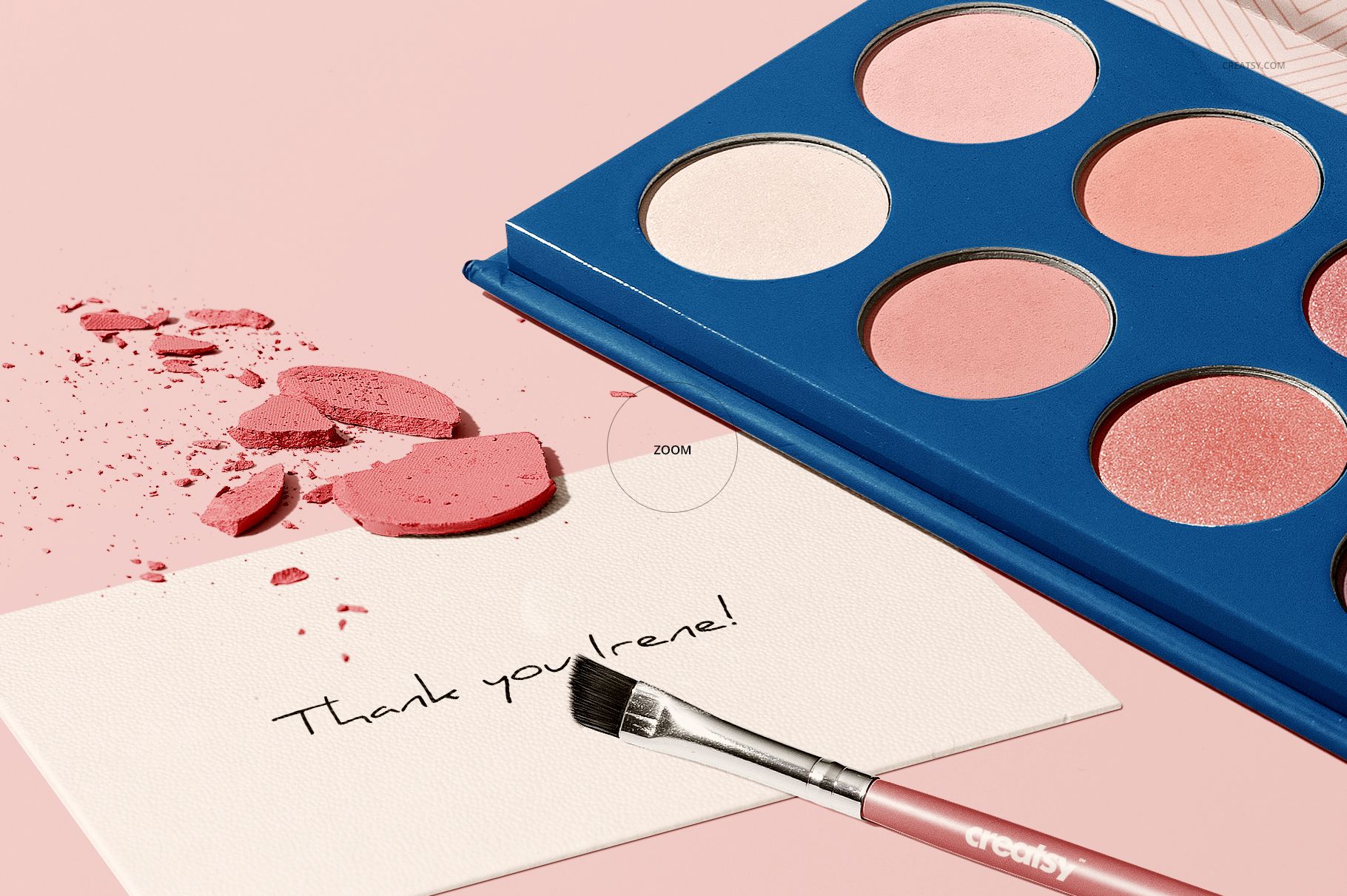 Open eyeshadow palette mockup with six circular shades, makeup brush, and broken powder on a pastel pink background.